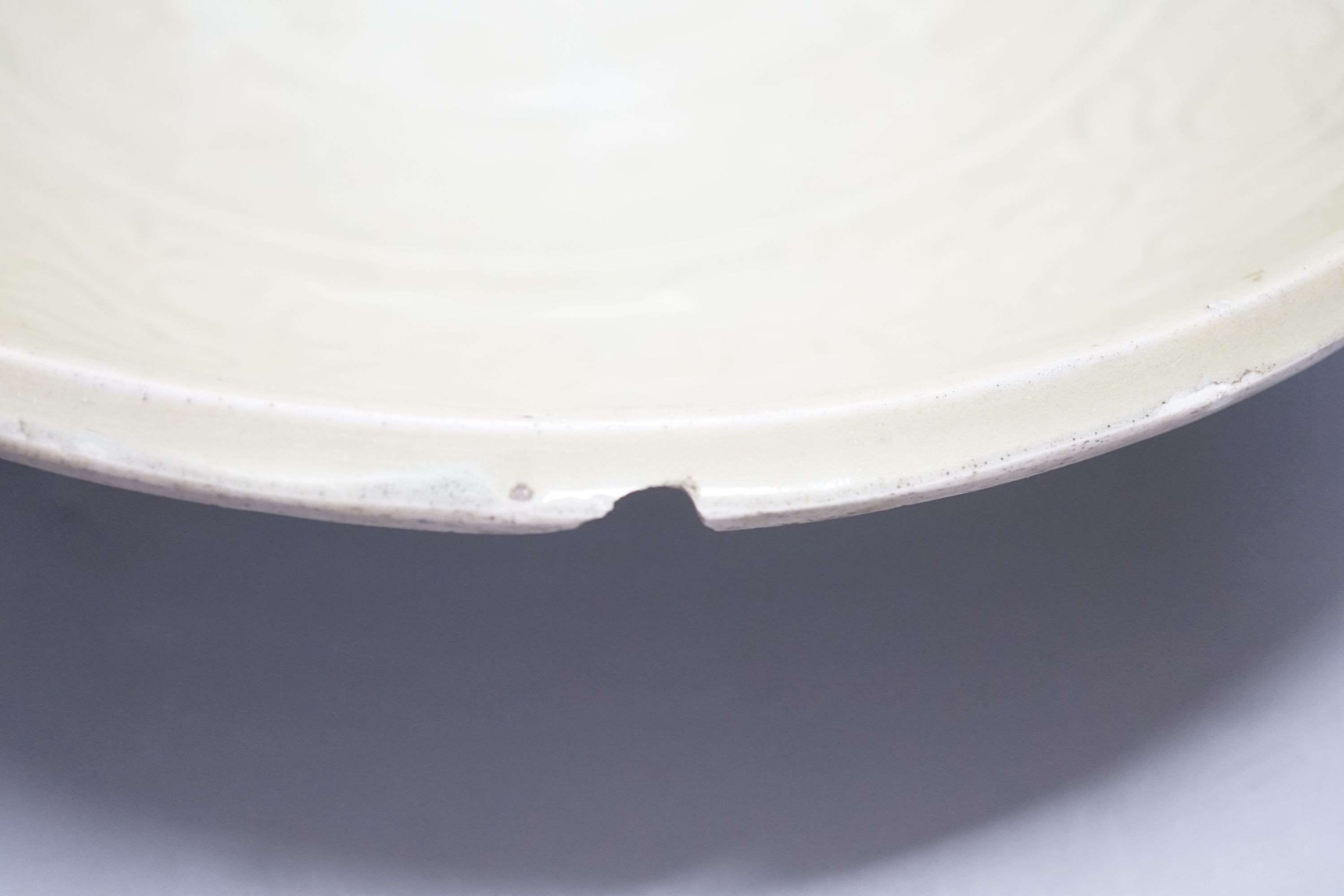 A Chinese Ming Longquan celadon dish, 15th/16th century, rim cut down, width 33cm